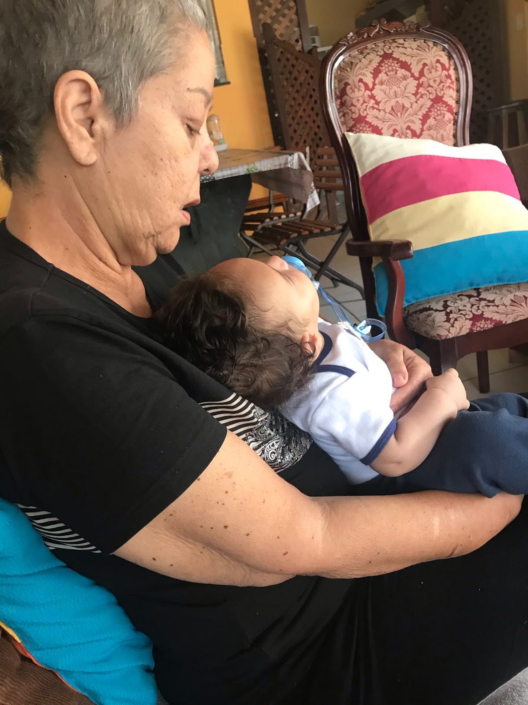 Avó com o neto bebê dormindo no colo